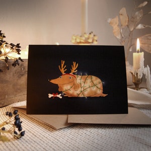 Set: gevouwen kerstkaart + envelop, feestelijke hond met gewei, A6 ansichtkaart