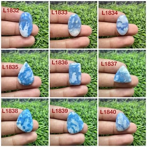 May include: A collection of nine polished blue and white patterned gemstones labeled L1832 through L1840. Each stone features unique cloud-like marbling in shades of sky blue and opaque white, presented in various shapes including oval, pear, and triangle.