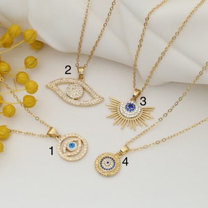 May include: Four gold necklaces with different evil eye pendants. The pendants are all adorned with clear rhinestones and blue enamel. The necklaces are numbered 1 through 4.