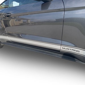 May include: A gray Ford Mustang with a black and silver stripe along the side. The word "Mustang" is printed in silver on the side of the car.