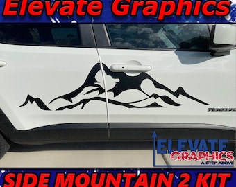 May include: Black mountain range decal for a white car. The decal is on the side of the car and says "Side Mountain 2 Kit". The decal is from Elevate Graphics.