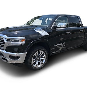 May include: Black Ram pickup truck with chrome accents and white and black graphic decals on the sides. The truck has a black grille with a chrome RAM logo.
