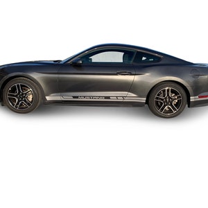 May include: A dark gray Ford Mustang with black wheels and a silver stripe along the side that says "Mustang".