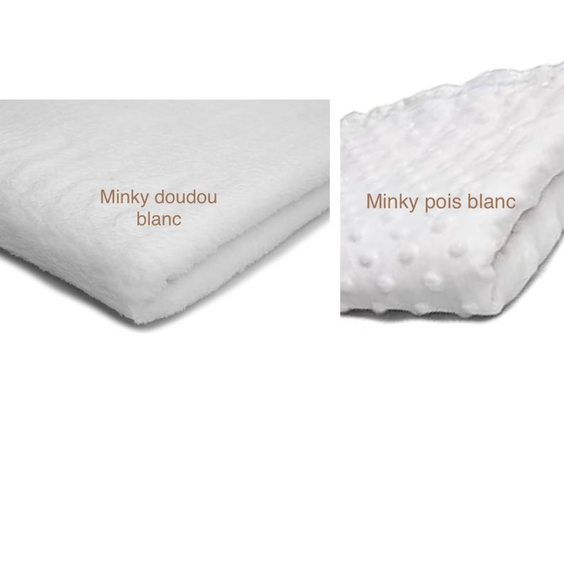 Op de afbeelding: Twee witte minky stoffen. E&eacute;n is glad en de andere heeft kleine witte stippen. De tekst "Minky doudou blanc" staat op de gladde stof en de tekst "Minky pois blanc" staat op de stof met stippen.