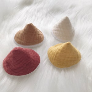 Peut inclure: Quatre chapeaux en tissu en forme de cône de différentes couleurs : rouge, marron, jaune et blanc. Les chapeaux ont une bordure blanche autour du bord inférieur.