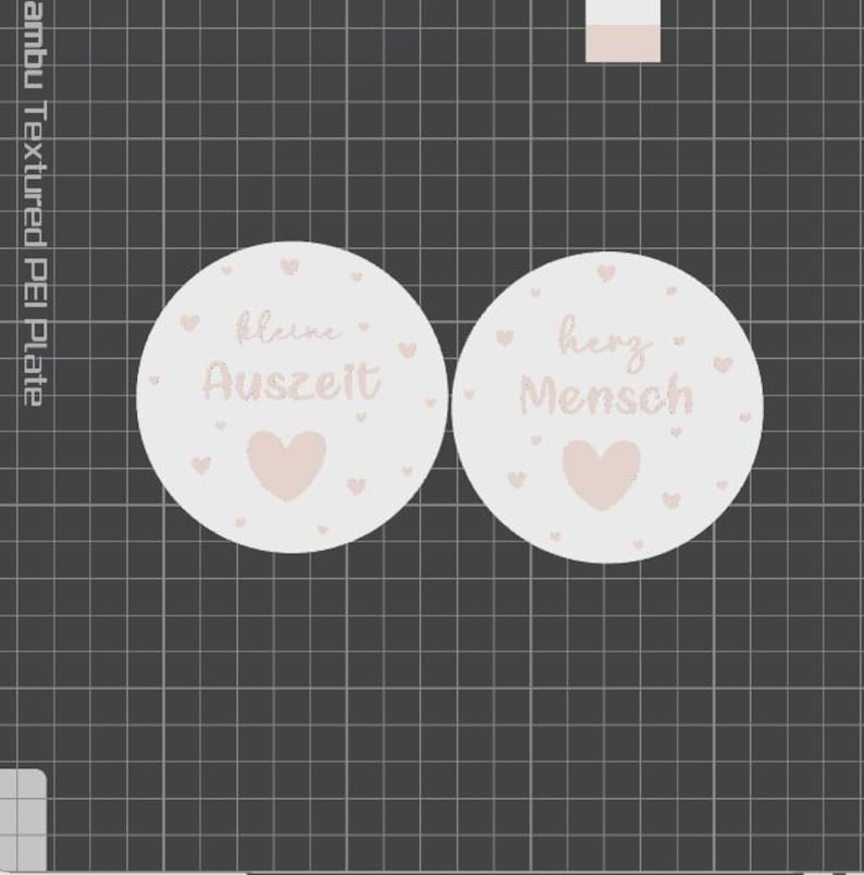 May include: Two round, light pink stickers with text and heart designs. One sticker reads "kleine Auszeit" and the other reads "herz Mensch". The stickers have a soft, pastel aesthetic, with small hearts scattered around the text and a larger heart at the bottom.