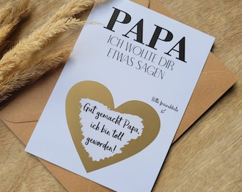 May include: A white card with the word "PAPA" in large black letters. Below, the text reads "ICH WOLLTE DIR ETWAS SAGEN." A gold heart shape is in the center with the text "Gut gemacht Papa, ich bin toll geworden!" The card is in a brown envelope.