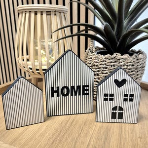 Könnte beinhalten: Rustikales Holzschild mit dem Text "Welcome to our home" in weißer Schrift. Das Schild hat eine Used-Optik und ein schlichtes, einladendes Design, perfekt für eine Veranda oder einen Eingangsbereich.