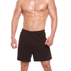 May include: A man wearing black athletic shorts with a button fly.