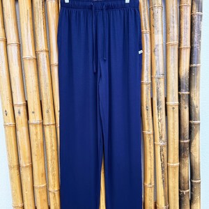 May include: Navy blue lounge pants with a drawstring waist and a small tag on the right hip.