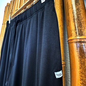 May include: Black drawstring sweatpants with a white tag that says "Spun Bamboo".