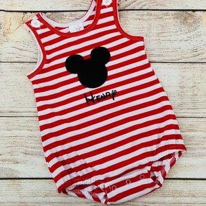 May include: Red and white striped baby onesie with a black Mickey Mouse head and the name "Henry" embroidered on the front.