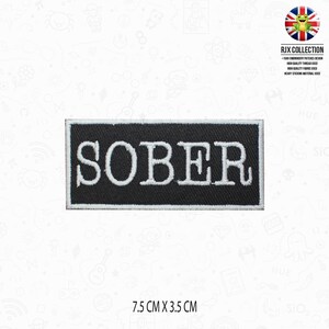 May include: A black rectangular patch with the word "SOBER" embroidered in white. The patch measures 7.5 cm x 3.5 cm. The patch is from the RJX Collection.