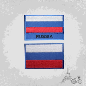 Puede incluir: Dos parches bordados con la bandera rusa. El parche superior tiene la palabra "RUSSIA" bordada debajo de la bandera. Ambos parches son azules, blancos y rojos.