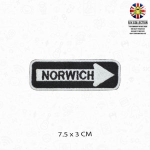 May include: Black and white embroidered iron-on patch with a white arrow pointing to the right and the word "NORWICH" in white text. The patch is 7.5 cm by 3 cm.