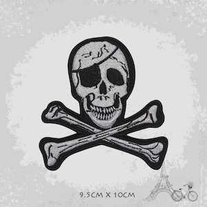 Op de afbeelding: Een grijs en zwart geborduurde strijk-op patch van een schedel en gekruiste beenderen. De schedel heeft een ooglapje en een tanden glimlach. De patch meet 9,5 cm bij 10 cm.