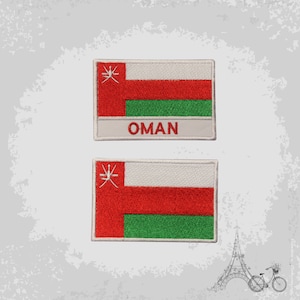 Pode incluir: Dois patches bordados da bandeira de Omã. Os patches são brancos com uma faixa vermelha, uma faixa verde e uma estrela vermelha com contorno branco no canto superior esquerdo. A palavra "OMÃ" está escrita em vermelho abaixo da bandeira no patch superior.