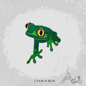 Puede incluir: Parche de rana verde bordado con un ojo amarillo. El parche mide 7,5 cm por 8 cm.