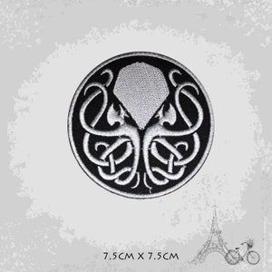 May include: A black and white embroidered patch featuring a stylized octopus with tentacles in a circular design. The patch is 7.5 cm in diameter.