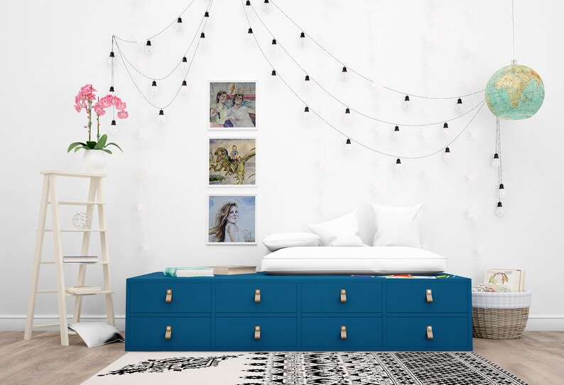 May include: A blue dresser with six drawers and gold handles. The dresser is in a bedroom with a white wall, a white bed, and a globe light hanging from the ceiling.