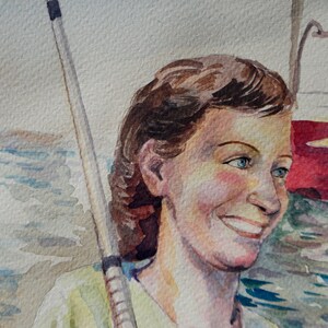 May include: Watercolor painting of a woman with brown hair and blue eyes. She is smiling and wearing a light green shirt. A fishing rod is behind her. The background is a watercolor wash of blue and white.