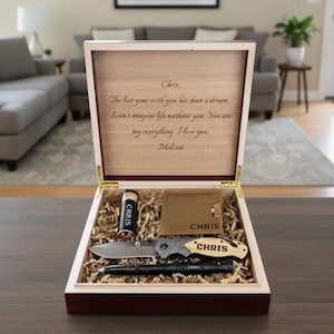 May include: A wooden gift box containing a tan leather wallet, a folding knife with a light wood handle, a black pen, and a small cylindrical container, all personalized with the name Chris. The lid interior features a printed love letter.