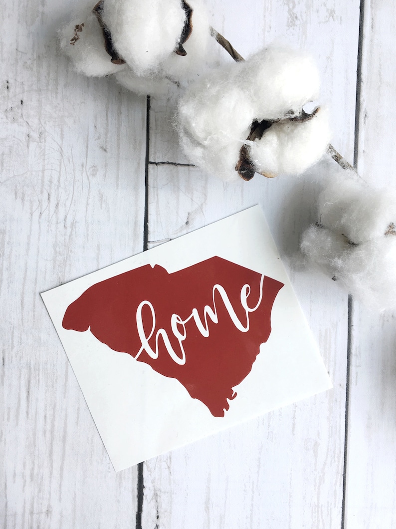 May include: A red vinyl decal of the state of South Carolina with the word "home" written in white cursive lettering.