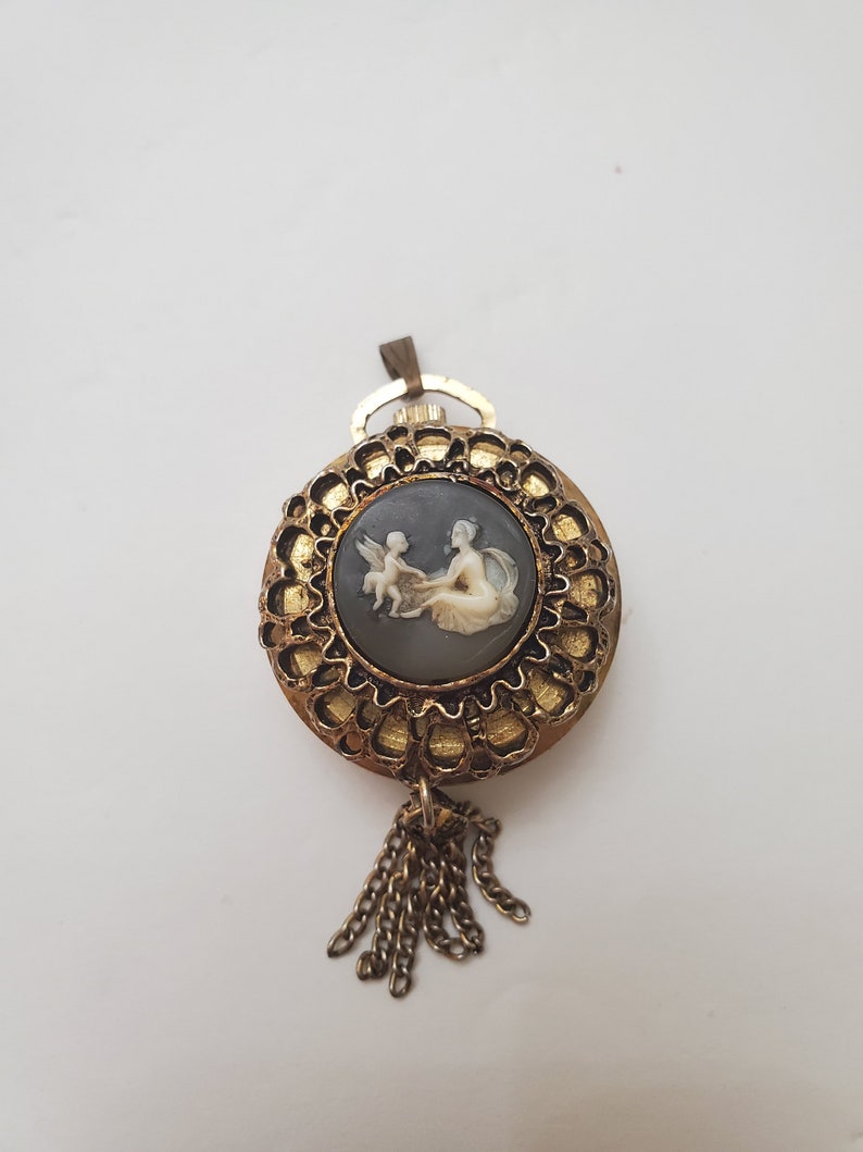 Lucerne watch with tassel - image depicting a woman with her child that has wings and shops a tail