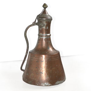 May include: A copper jug with a flared spout and a handle. The jug has a lid with a finial on top. The jug is tarnished and has a patina.