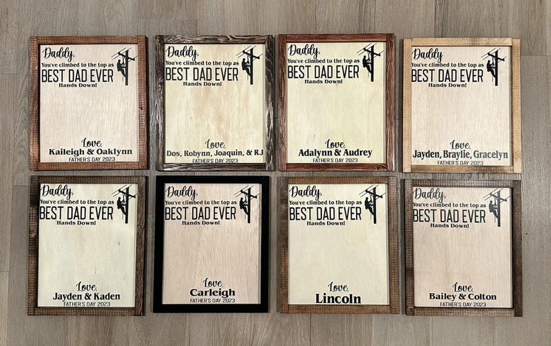 May include: Eight framed wood signs with a light brown background and black text. Each sign features a silhouette of a lineman climbing a utility pole. The text reads "Daddy, you've climbed to the top as BEST DAD EVER Hands Down!" Each sign has a different name and date at the bottom.