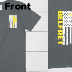 May include: A gray t-shirt with a yellow silhouette of a lineman climbing a utility pole on a distressed American flag design on the back. The front of the shirt has a smaller version of the design on the left chest. The text "BELLFRET" is on the back of the shirt.