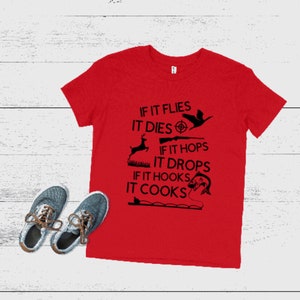 May include: Red t-shirt with a black graphic that says "If it flies it dies, if it hops it drops, if it hooks it cooks". The graphic also includes a bird, a deer, a rifle, a fish, and a fishing rod.