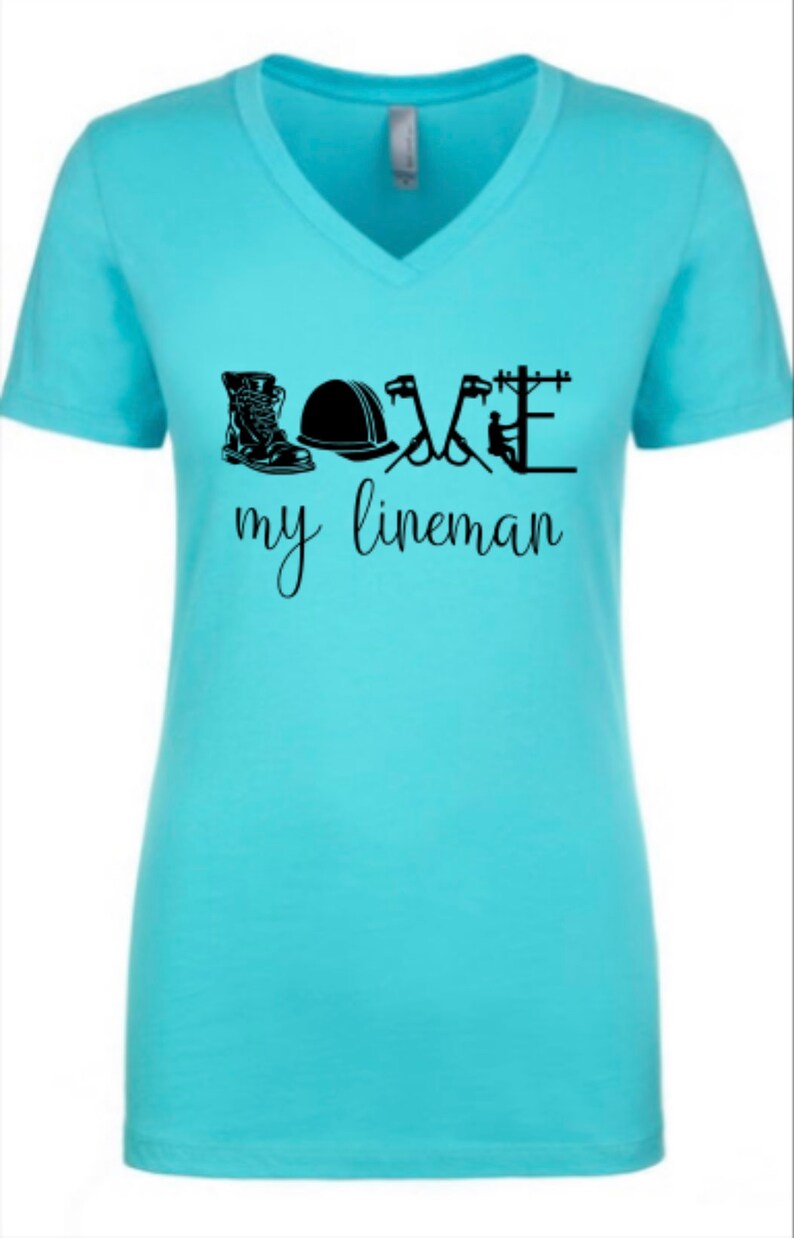 May include: A light blue t-shirt with a black graphic design that says "LOVE my lineman" with a boot, hard hat, pliers, and a lineman on a pole.