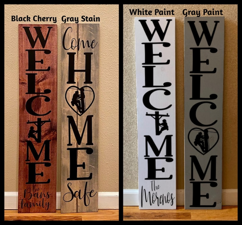 May include: Four wooden welcome signs with different paint colours and family names. The signs feature a silhouette of a lineman climbing a utility pole with a heart shape around it. The signs read "Welcome Home" with the family names "The Bans Family", "Safe", "The Morenos", and "Welcome".