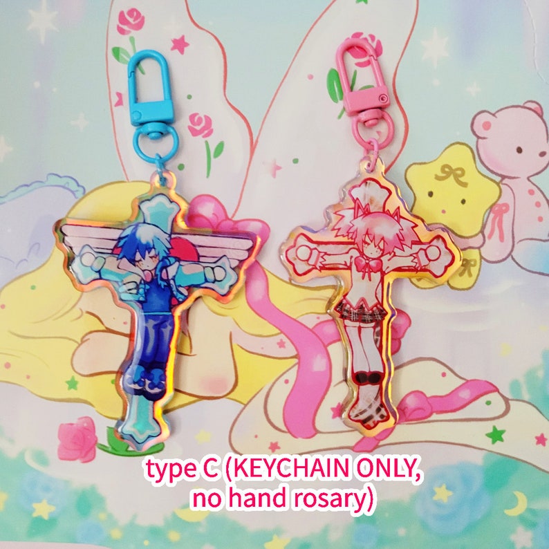 May include: Two colorful keychains featuring anime characters on a cross design. The keychain on the left is blue with a male character, and the keychain on the right is pink with a female character. The text "type C (KEYCHAIN ONLY, no hand rosary)" is visible at the bottom of the image.