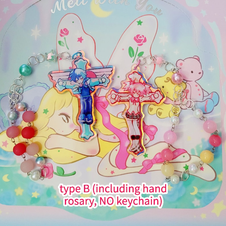 May include: A pink and blue hand-made rosary with two colorful cross charms featuring anime characters. The rosary is made with pastel pink, blue, and yellow beads. The text "type B (including hand rosary, NO keychain)" is printed on the bottom of the image.