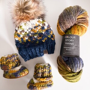 Puede incluir: Un conjunto de hilo grueso pintado a mano en tonos de marr&oacute;n, verde, amarillo y azul. El hilo est&aacute; hecho en Per&uacute; y est&aacute; disponible para comprar en el sitio web de Colour Story Yarns. El hilo tambi&eacute;n se utiliza para hacer un gorro de punto con un pomp&oacute;n y un par de botines de punto para beb&eacute;.