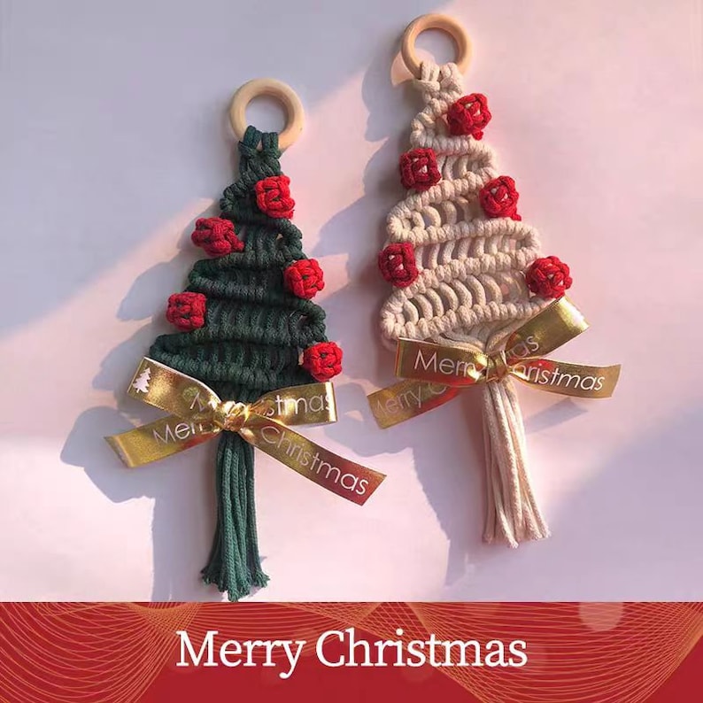 Op de afbeelding: Twee handgemaakte macram&eacute; kerstboomversieringen met rode pompoenen en een gouden lint met de tekst "Merry Christmas".