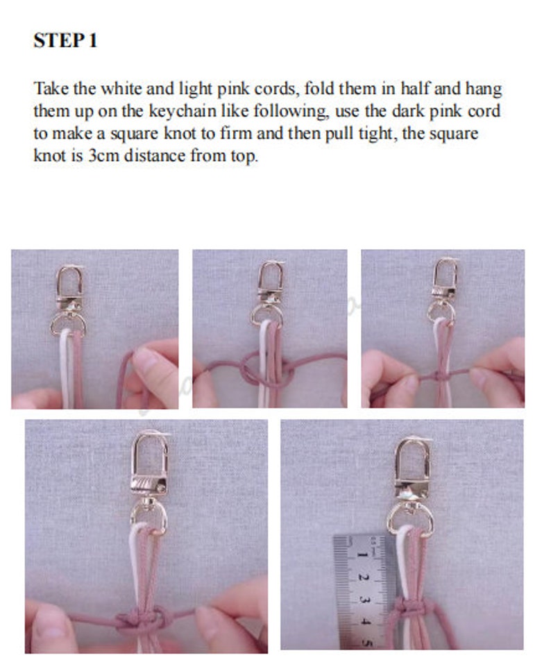 Może przedstawiać: Krok 1 projektu DIY pokazującego, jak zrobić brelok. Obraz przedstawia biały sznurek, jasnor&oacute;żowy sznurek i ciemnor&oacute;żowy sznurek związane razem kwadratowym węzłem wok&oacute;ł srebrnego breloka. Węzeł znajduje się 3 cm od g&oacute;ry breloka.