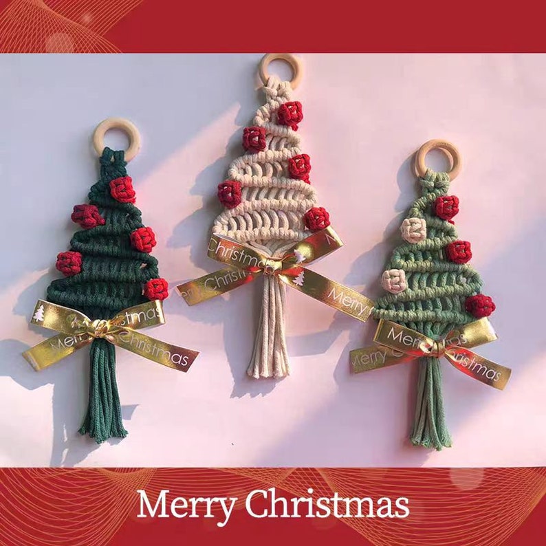 Op de afbeelding: Drie handgemaakte macram&eacute; kerstboomversieringen met rode en witte pompoenen, gouden lint en de tekst "Merry Christmas".