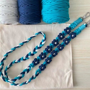 May include: A handmade macrame cord necklace with blue and white braided cord and flower accents.