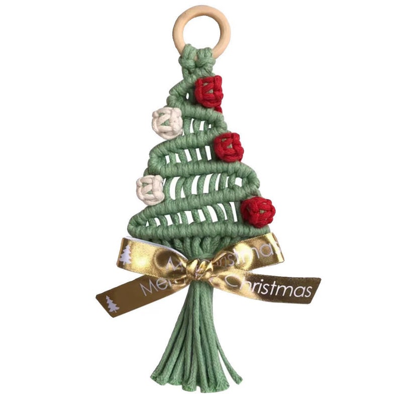 Op de afbeelding: Groene macram&eacute; kerstboom ornament met rode en witte pompoenen, een gouden lint met de tekst "Merry Christmas" en een groene kwast.