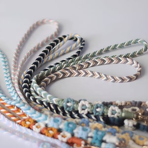May include: A collection of colorful braided cords in various patterns, including chevron and floral designs. The cords are made of cotton and are perfect for crafting projects.
