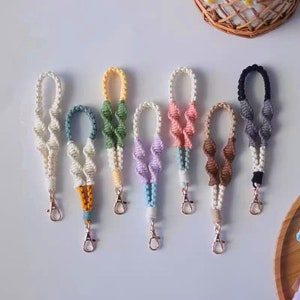 Puede incluir: Siete llaveros de crochet de colores con anillas de metal dorado. Los llaveros est&aacute;n hechos de hilo blanco, verde, rosa, morado, marr&oacute;n, gris y negro.