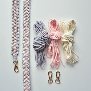 May include: A set of three spools of cord in gray, pink, and white, along with two gold metal clasps and a braided strap made from the three colors of cord.