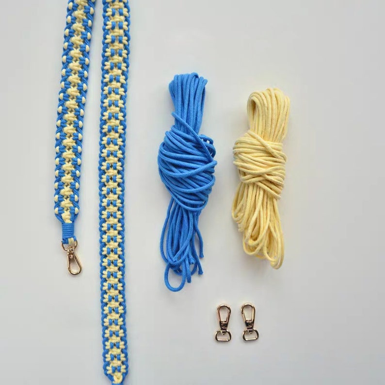 May include: A blue and yellow braided strap with two gold clasps, a spool of blue cord, and a spool of yellow cord.