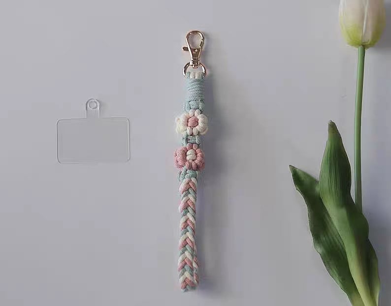 Pu&ograve; includere: Un portachiavi in macram&egrave; blu chiaro e rosa con tre accenti floreali. Il portachiavi ha un porta carte in plastica trasparente.