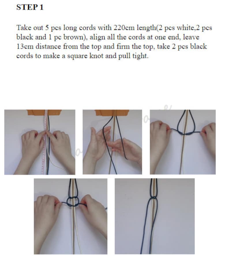 May include: Step 1 of a macrame project. Five cords, two white, two black, and one brown, are aligned at one end. The cords are 220 cm long. The cords are held in place with a piece of tape. The cords are 13 cm from the top. Two black cords are used to make a square knot.