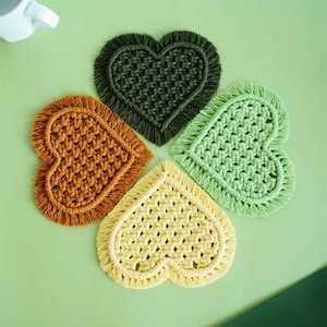 Peut inclure: Quatre dessous-de-verre en forme de cœur en crochet de couleur verte, jaune et orange avec des détails en frange.
