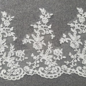 May include: White lace trim with a floral design. The lace is approximately 2 inches wide.